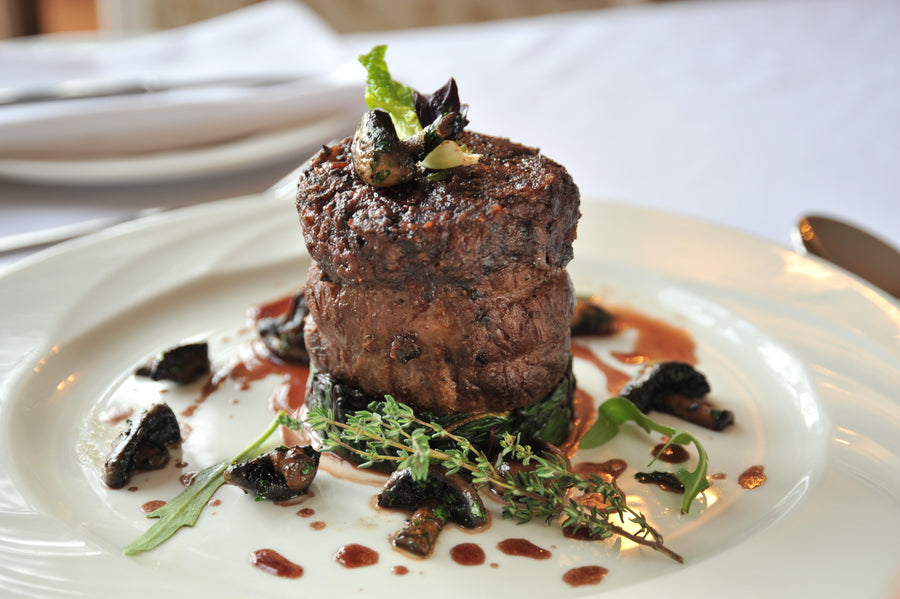 Beef fillet steak with mushrooms on a dark plate